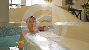 Attractive woman has time in pool at spa center.