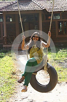 Attractive Woman having fun on tire swing
