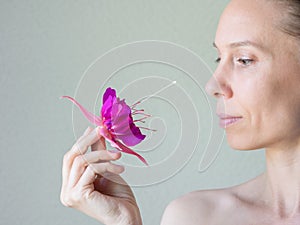 Attractive woman in her forties with a flower in hand