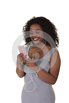 An attractive woman in her twenties wearing ear buds looking at her phone