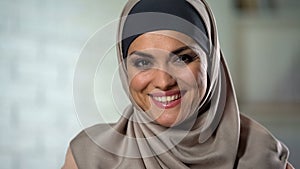 Attractive woman in hijab smiling at camera, arab fashion beauty, femininity