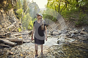 Attractive Woman hiking across a mountain stream on a hike