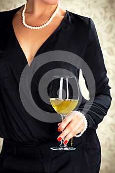 Attractive woman holding glass of white wine.