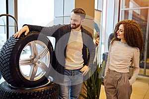 Attractive woman holding her hands in the pockets and buying tires