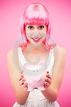 Attractive woman holding piggy bank