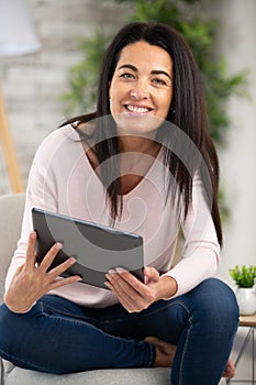 Attractive woman at home holding tablet