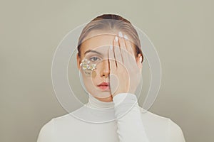 Attractive woman with hope inscription covering her eyes on white background