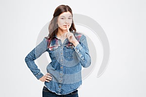 Attractive woman in jeans shirt standing and showing silence gesture