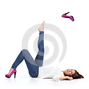 Attractive woman with jeans throwing a fuchsia heel