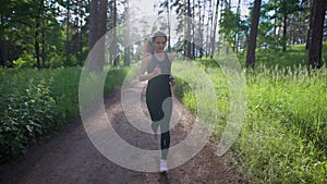 Attractive woman jogging on the trail in the park. Sport and recreation