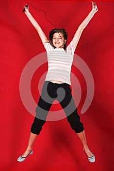 Attractive woman jumping of joy over red