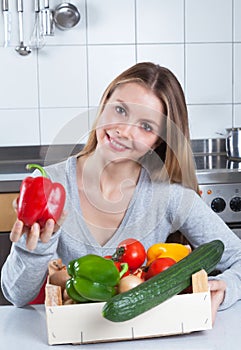 Attractive woman in the kitchen loves fresh vegetables