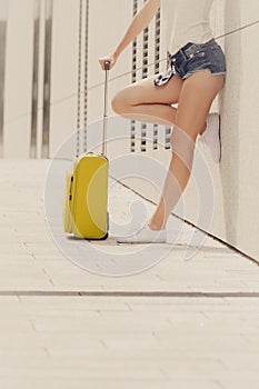 Attractive woman legs walking with green suitcase