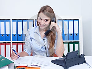 Attractive woman with long blond hair at office talking at phone