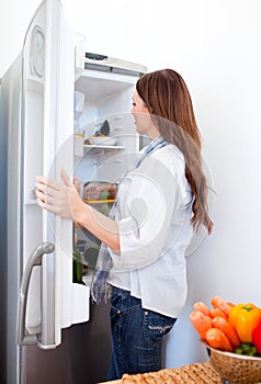 Attractive woman looking into the fridge