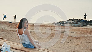 Attractive woman looks happy while sitting on the sand