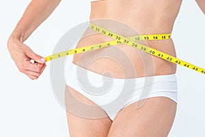 Attractive woman measuring her belly