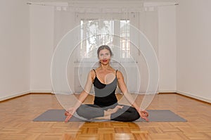 Attractive woman meditating alone in a room