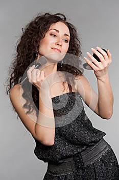 Attractive woman with morror and brush