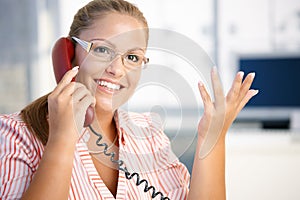 Attractive woman on the phone in office smiling