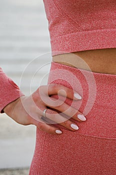 Attractive woman in pink red sportswear. Concept of fashionable sport outfit, vertical photo. The concept of sports, healthy