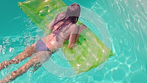 Attractive woman in the pool with lilo