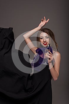 attractive woman posing with glass of champagne for fashion shoot