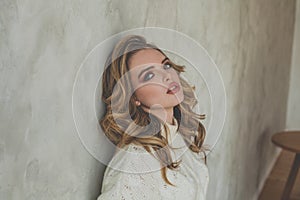 Attractive woman posing near gray stucco wall