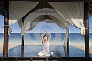 Attractive woman practice yoga at luxury beach resort