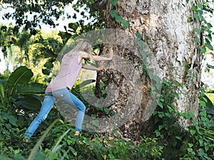 An attractive woman pushes a large tree