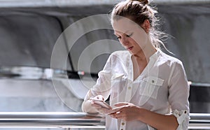 Attractive woman reading information in internet while walking in an urban street. Technology concept