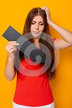 Attractive woman in a red t-shirt is holding a down arrow.
