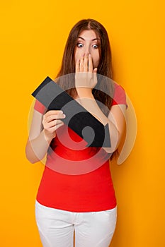 Attractive woman in a red t-shirt is holding a down arrow.