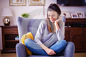 Attractive woman relaxing in the armchair at home