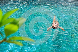 Attractive woman relaxing in luxury spa hotel at infinity pool