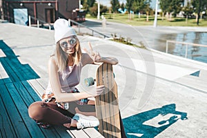 Attractive woman relaxing on the steps after longboard riding
