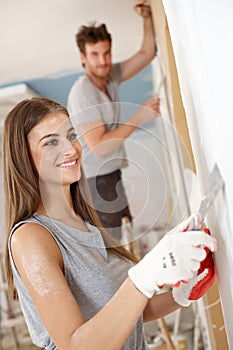 Attractive woman renovating house smiling