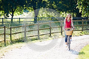 Attractive Woman Riding Bike Along Country Lane