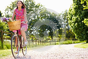 Attractive Woman Riding Bike Along Country Lane