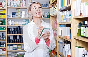 Attractive woman seller writing down care products in shop