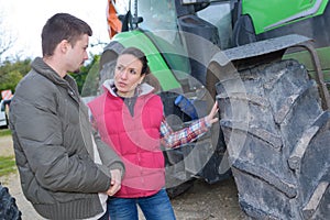 Attractive woman selling brand new tractor to beginner farmer