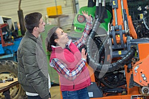 attractive woman selling brand new tractor to beginner farmer