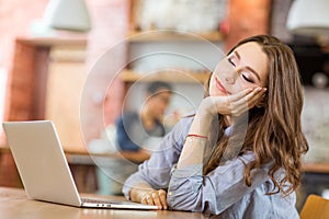 Attractive woman sitting in cafe with closed eyes and dreaming