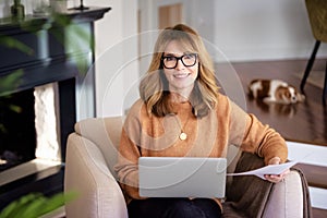 Attractive woman sitting at home and using laptop for work