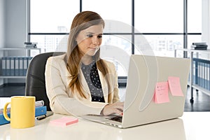 Attractive woman sitting at office chair working at laptop computer desk