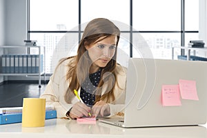 Attractive woman sitting at office chair working at laptop computer desk
