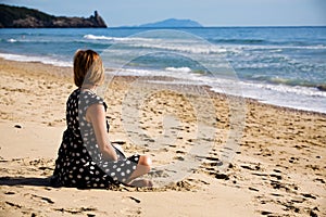 Attractive woman sitting on a sea coast