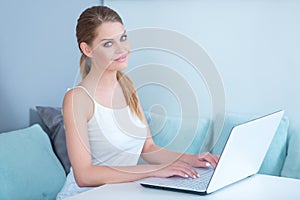 Attractive woman sitting using a laptop at home