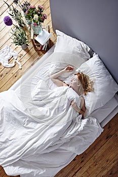 Attractive woman sleeping in white bed