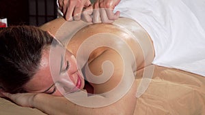 Attractive woman smiling with eyes closed, enjoying soothing back massage